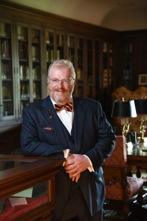 President Green leaning on a desk in his study.